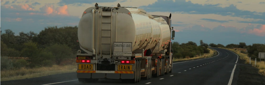 Fuel tanker on a highway, representing volatile gas prices affecting U.S. household costs.
